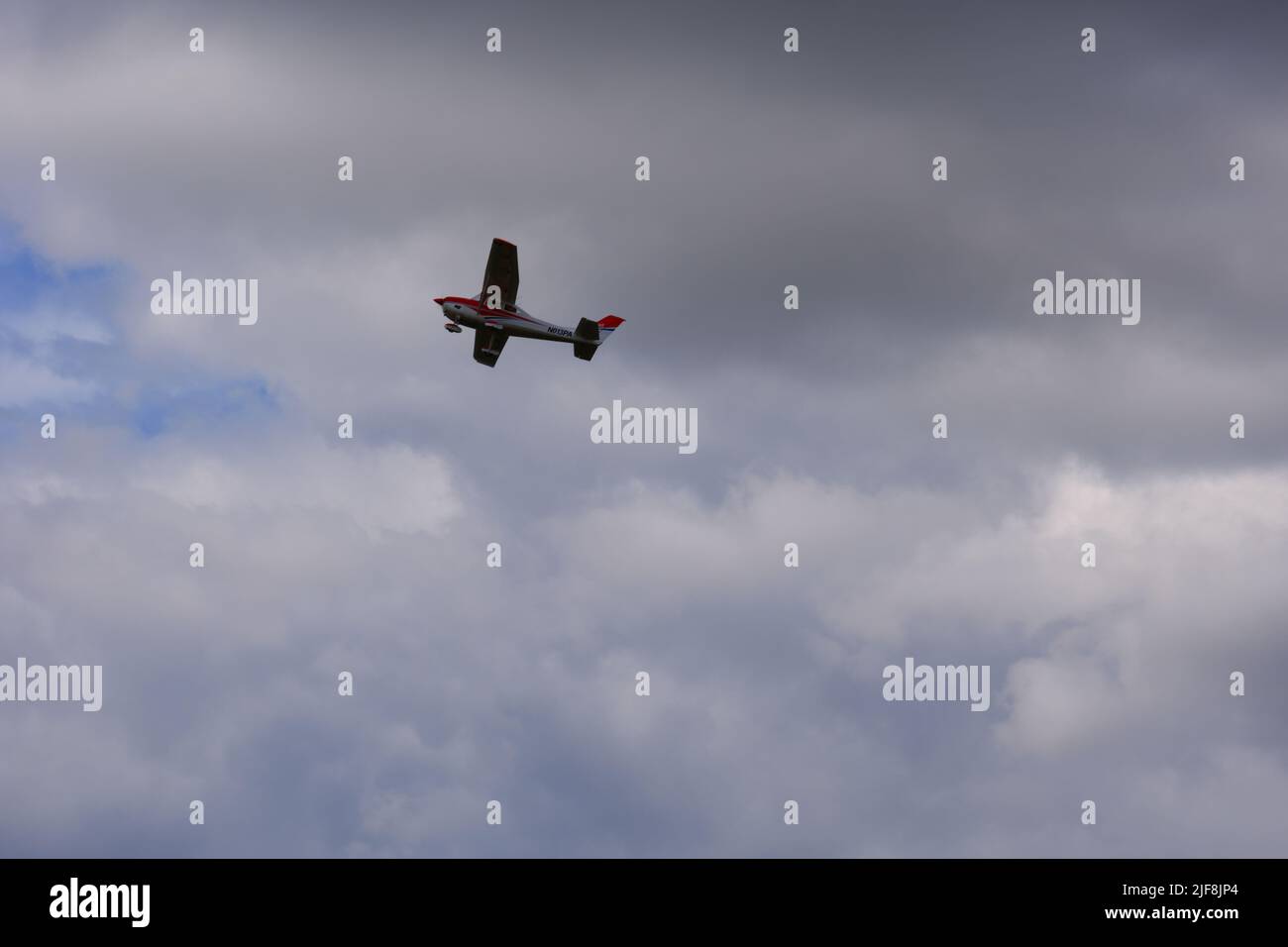 Piccolo aereo che vola all'interno di nuvole scure Foto Stock