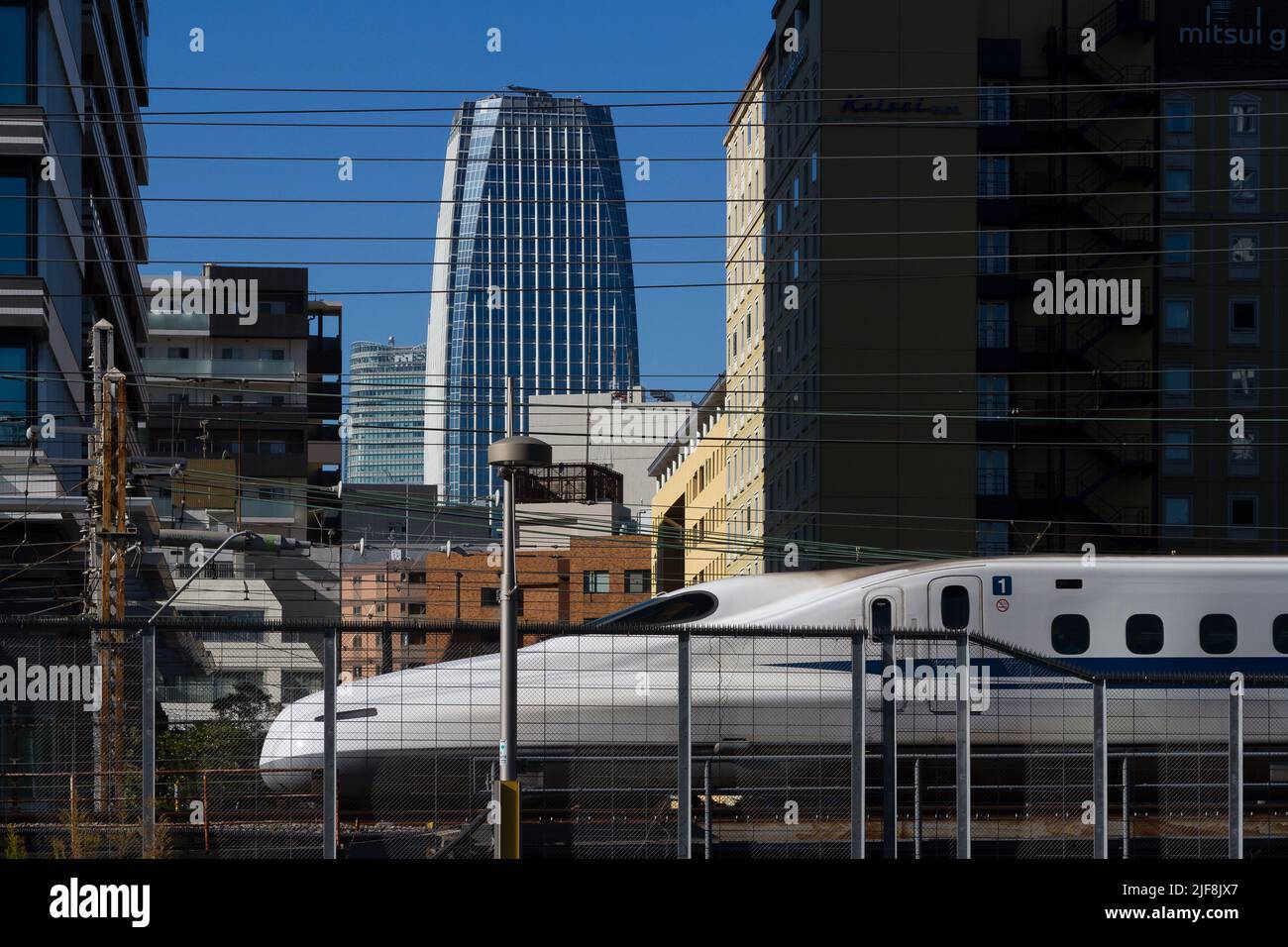 Un treno superveloce Shinkansen serie N700 passa attraverso gli edifici di Shimbashi, Tokyo, Giappone. Foto Stock