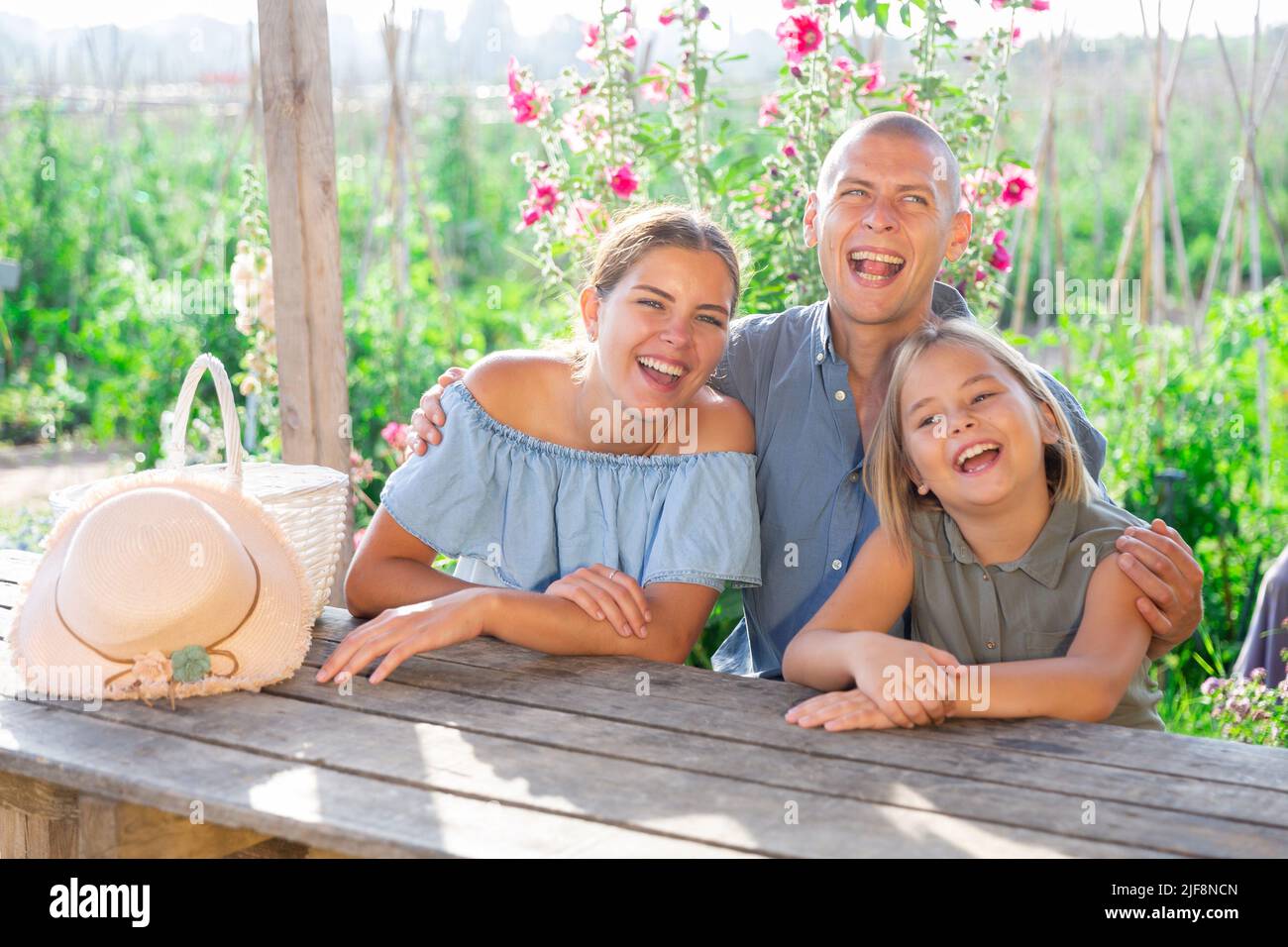 Ritratto di famiglia felice a tavola nel cortile della casa di campagna Foto Stock