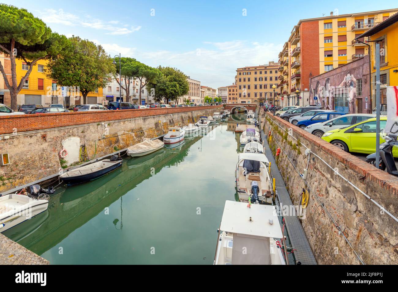 Le barche costeggiano gli affollati canali accanto alla Nuova Fortezza e un caffè sul lungomare all'aperto presso la città toscana di Livorno, Italia. Foto Stock