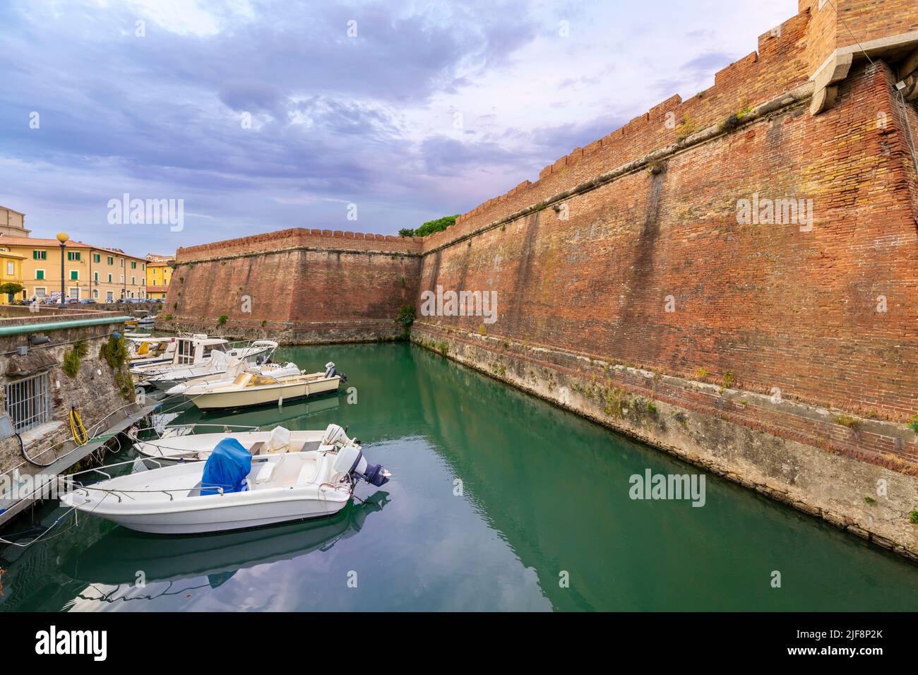 Le barche costeggiano gli affollati canali accanto alla Nuova Fortezza e un caffè sul lungomare all'aperto presso la città toscana di Livorno, Italia. Foto Stock