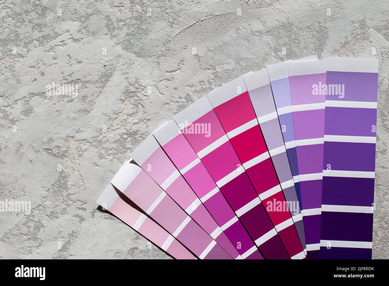 Catalogo tavolozza colori campioni viola, carte di selezione vernice su sfondo di pietra grigia Foto Stock