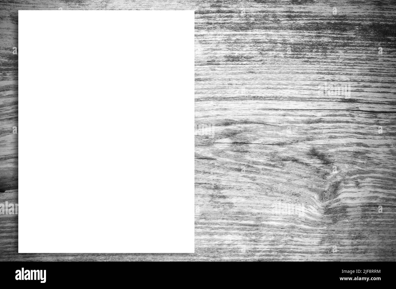 Vista dall'alto della carta bianca sullo sfondo di un tavolo in legno d'epoca. Pagina vuota su sfondo di legno per mockup. Foto Stock