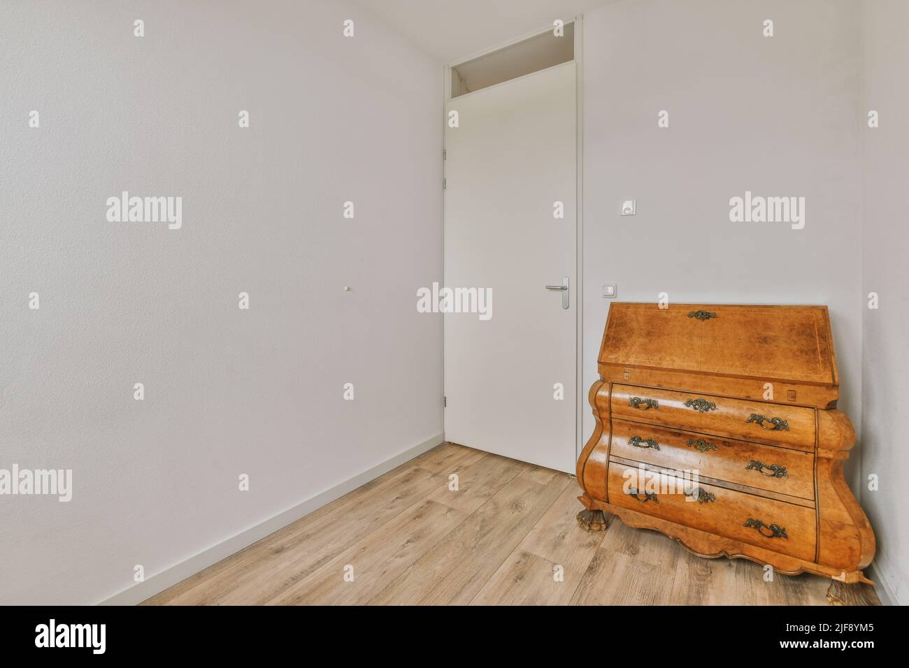 Interni minimalisti della sala studio con pavimento in parquet e pareti bianche arredate con divano e tavolo Foto Stock