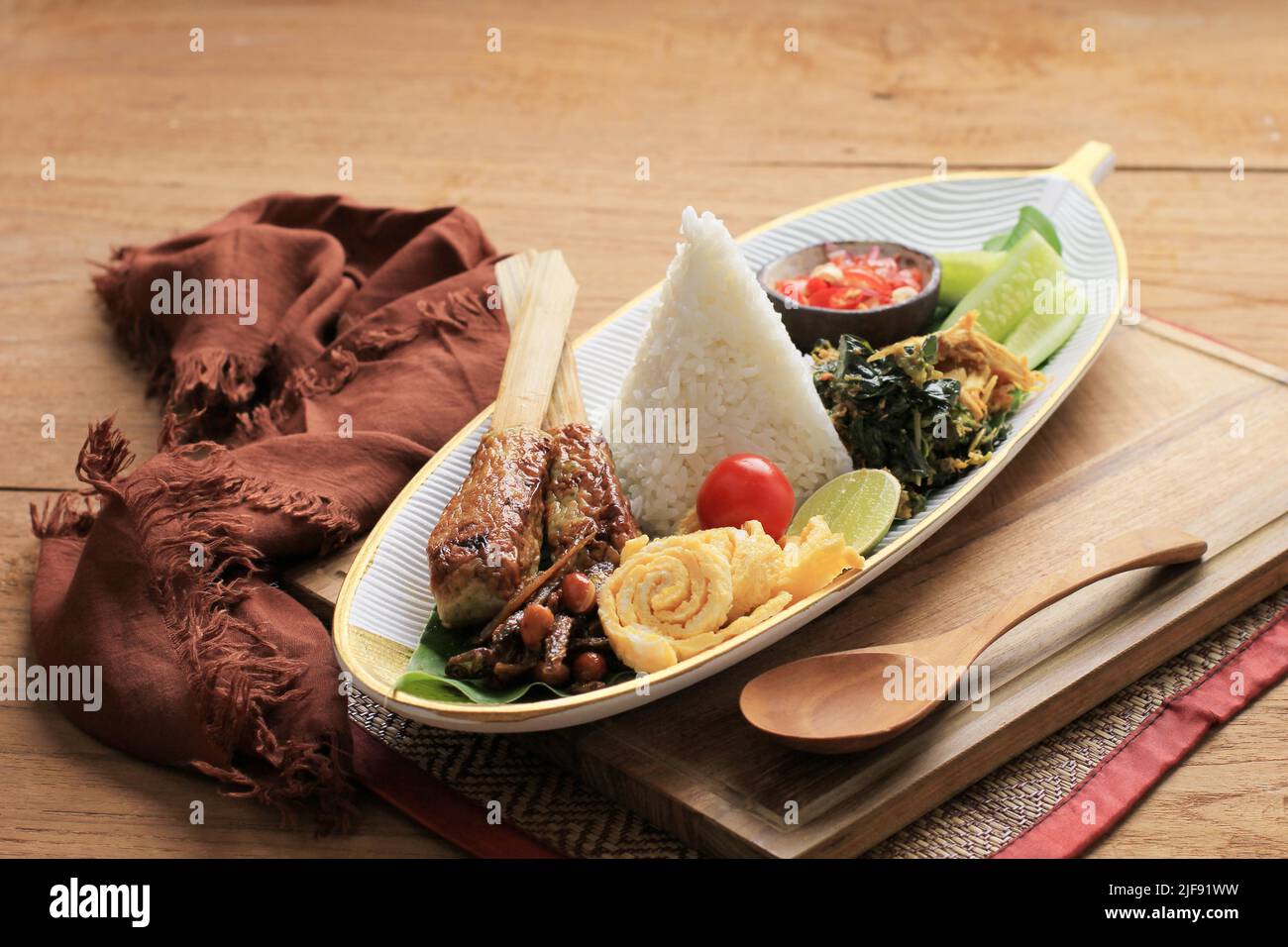 Nasi Campur Bali. Piatto balinese di riso al vapore con una varietà di contorni, come Sate Lilit, Ayam Pelalah, Telur Dadar, Kacang Teri, Jukut Urap. O Foto Stock