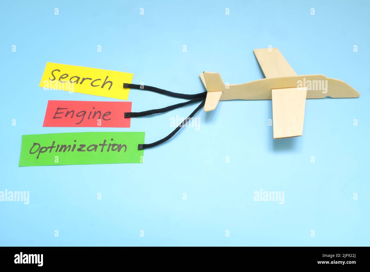 Parola chiave e ottimizzazione di Search Engine o importanza di SEO e chiave per concetto di successo nell'introduzione sul mercato di affari. Modello di aeroplano che trasporta lo striscione di carta. Foto Stock