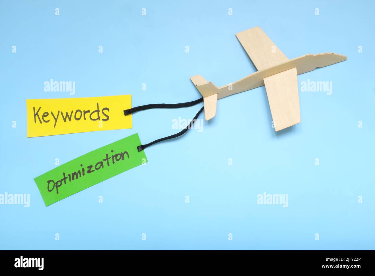 Parola chiave e ottimizzazione di Search Engine o importanza di SEO e chiave per concetto di successo nell'introduzione sul mercato di affari. Modello di aeroplano che trasporta lo striscione di carta. Foto Stock