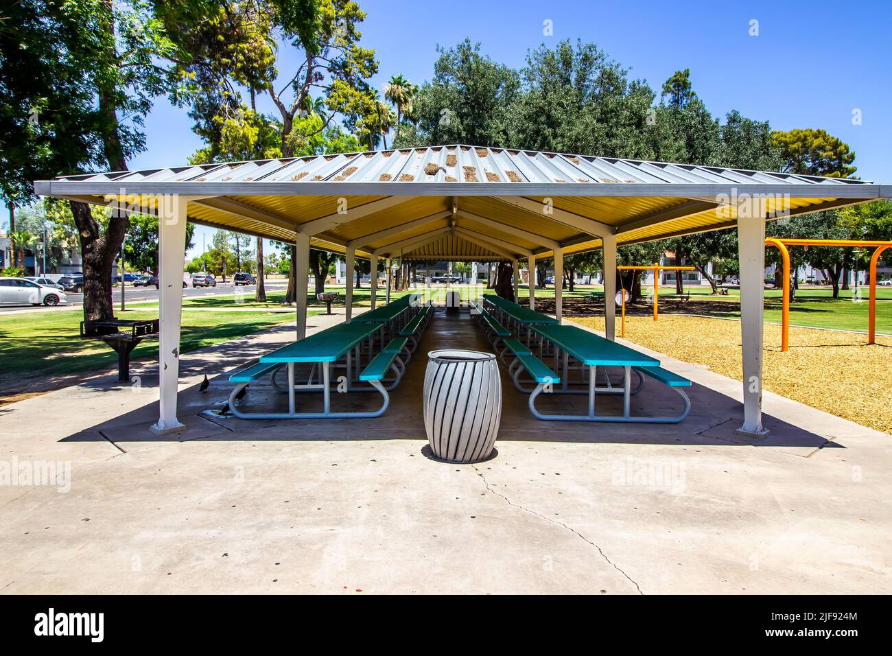 Grande Pergola che copre file di tavolo da picnic nel Parco pubblico gratuito Foto Stock