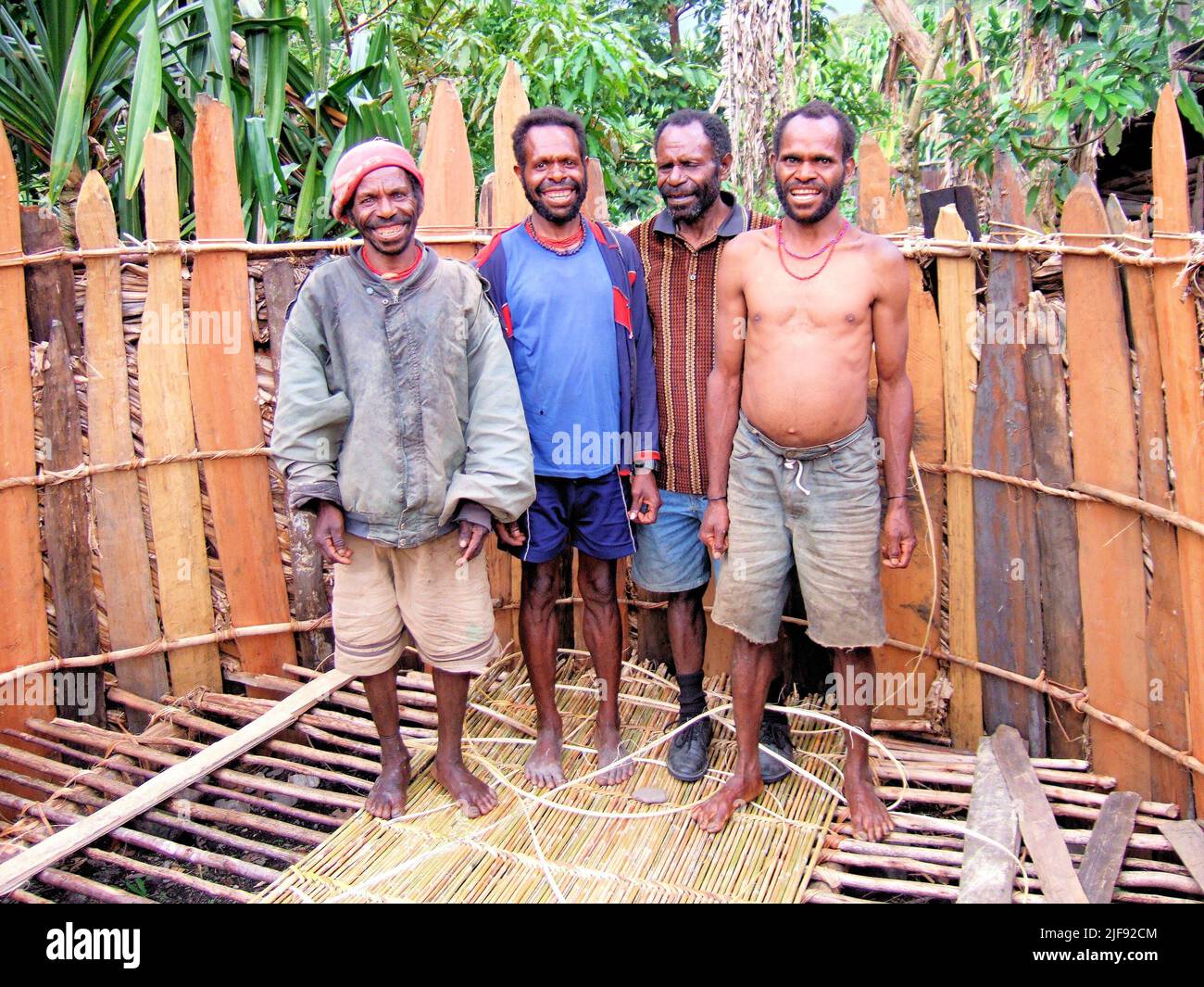 Quattro uomini costruendo una casa negli altopiani di Papua, Indonesia. Foto Stock