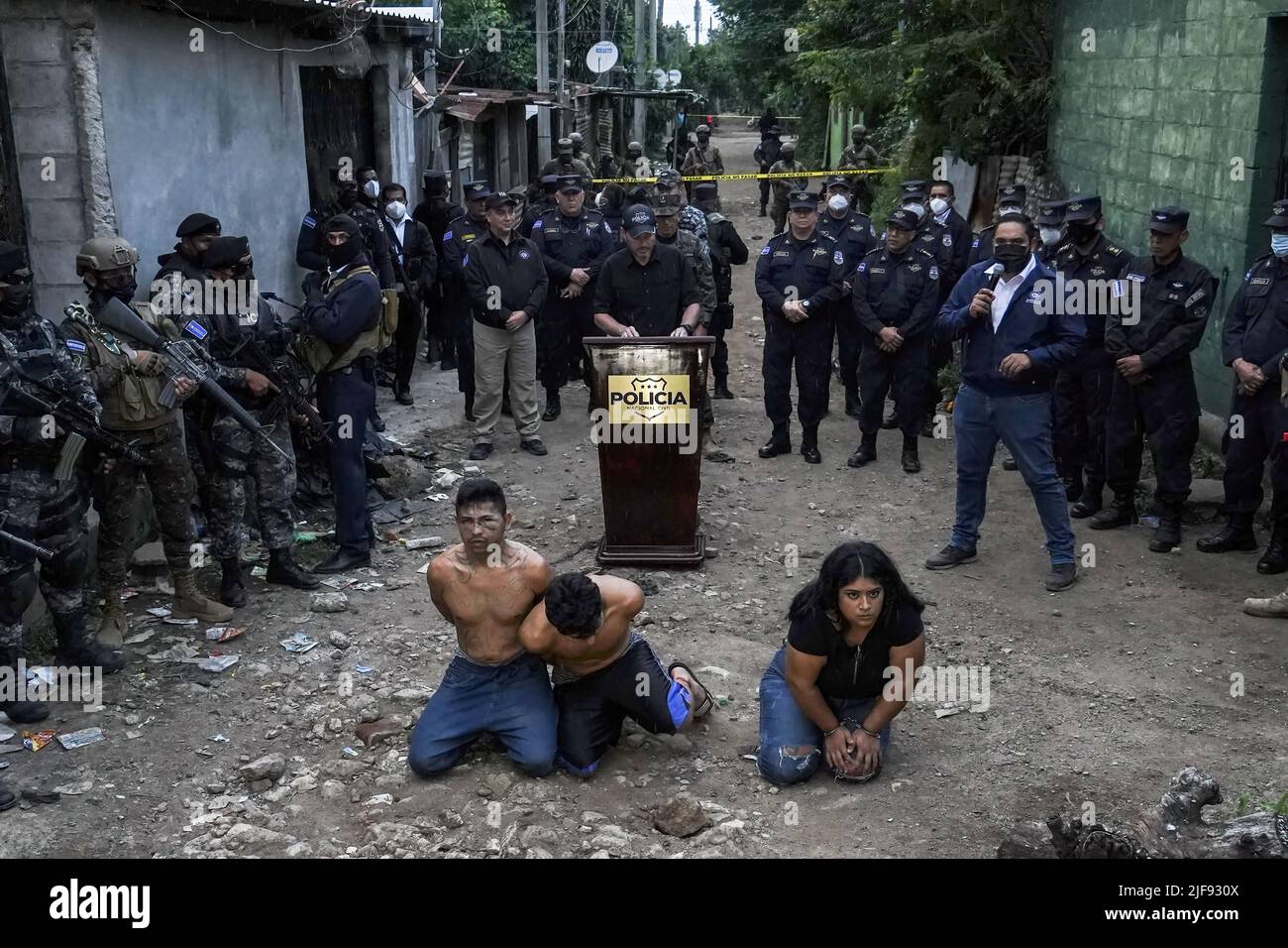 Santa Ana, El Salvador. 30th giugno 2022. I membri della banda Barrio 18 Sureños guardano mentre sono presentati dalle autorità di sicurezza alla stampa nel quartiere 'la Realidad'. Il governo Salvadoran ha catturato tre membri della banda Barrio 18 Sureños dopo l'uccisione di tre poliziotti il 28 giugno, durante i compiti di sicurezza parte del Congresso ha approvato lo stato di emergenza contro bande che ha lasciato più di 40.000 presunti criminali incarcerati. Credit: SOPA Images Limited/Alamy Live News Foto Stock