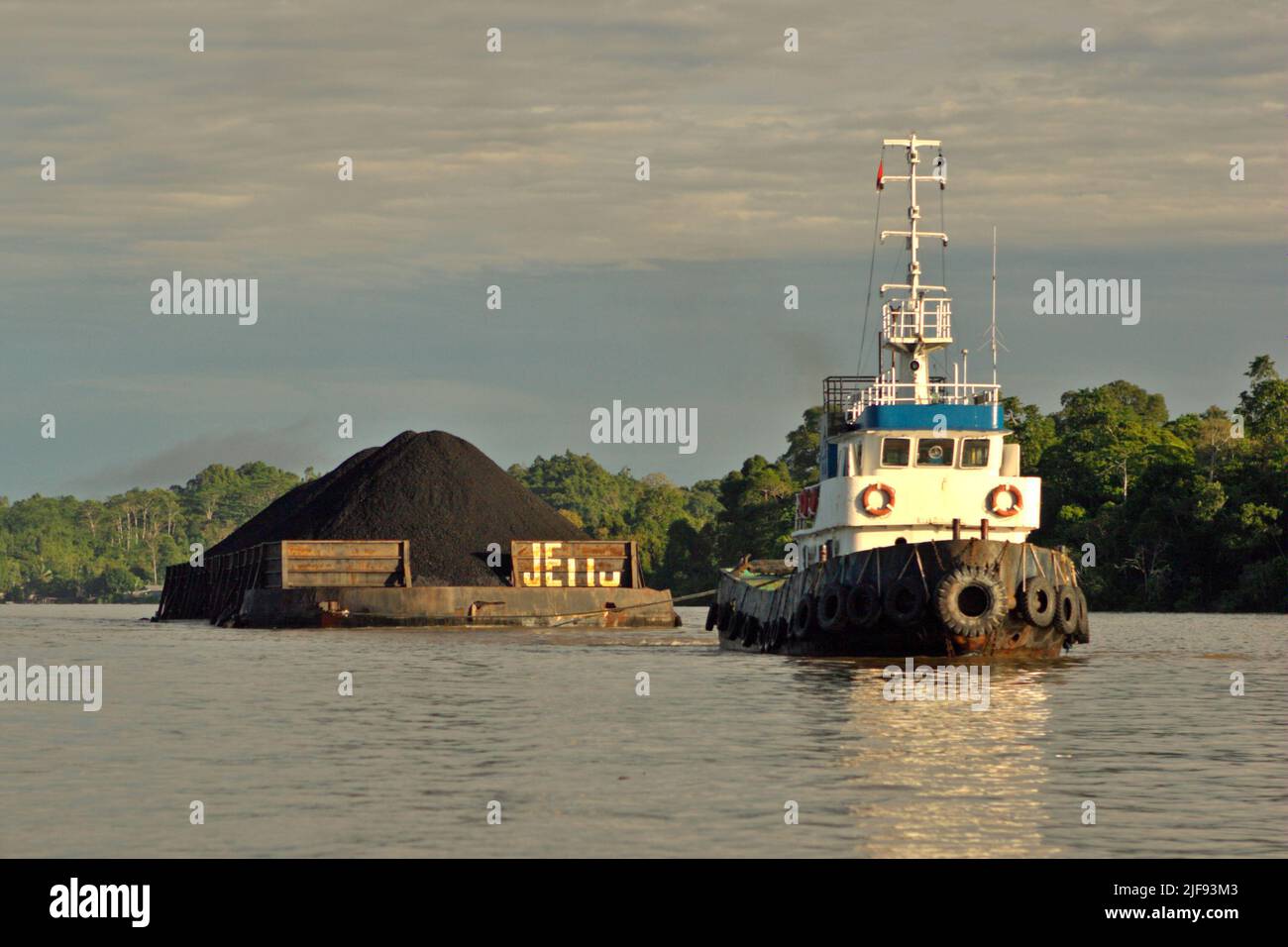 Una chiatta di carbone è trainata da un rimorchiatore sul fiume Segah a Berau, Kalimantan orientale, Indonesia. Il paese potrebbe non essere in grado di soddisfare la crescente domanda di carbone da parte dei paesi europei che stanno cercando di fare scorte di combustibile sporco, poiché riducono le importazioni di energia dalla Russia, Jakarta Post ha riferito il 1 luglio 2022. Foto Stock