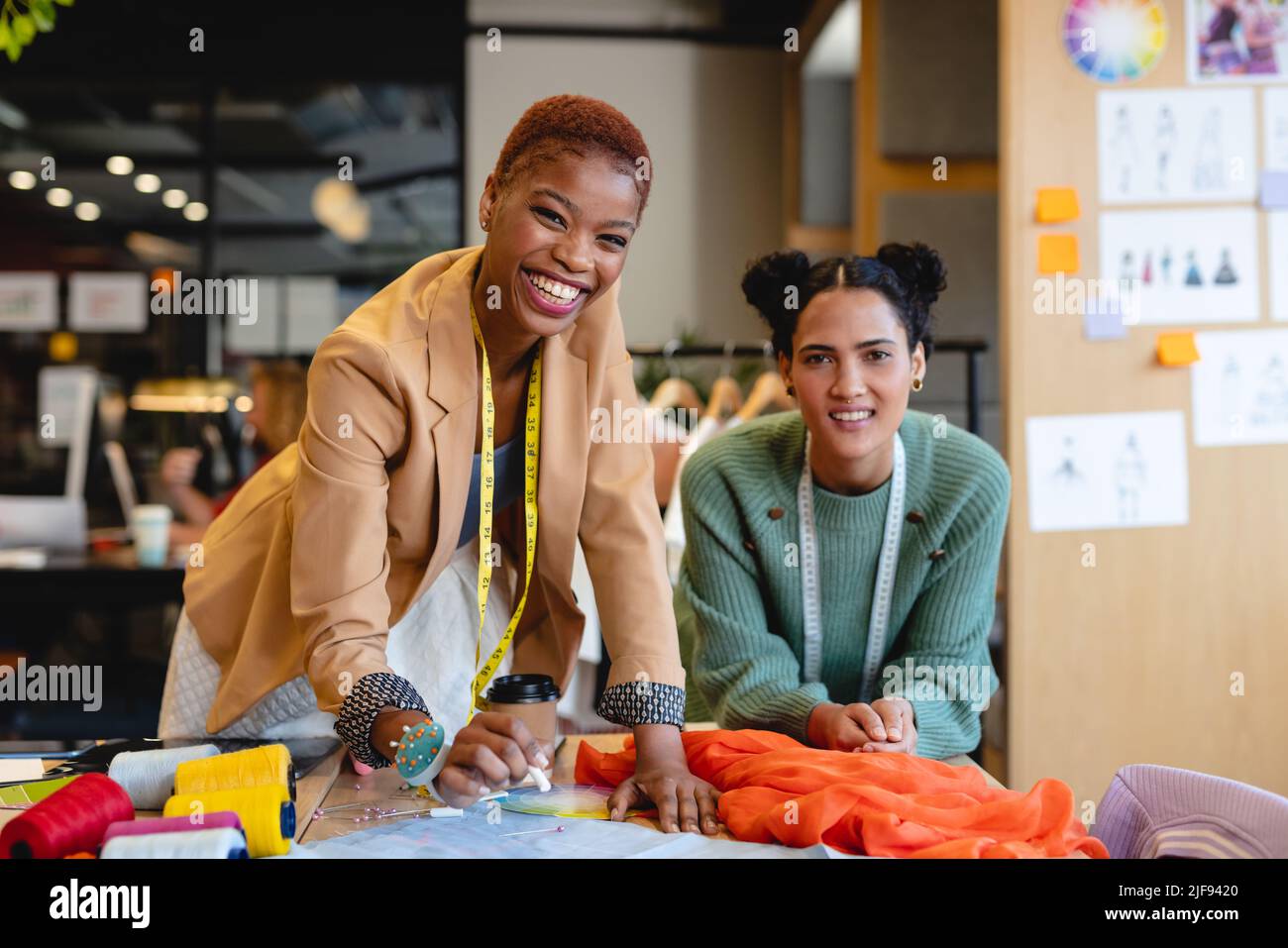 Ritratto di sorridente multirazziale giovani stilisti femminili che lavorano in ufficio Foto Stock