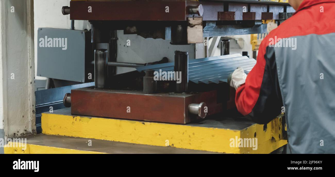 Lamiera in macchina e operaio della fabbrica di stampaggio, vista posteriore. Foto Stock