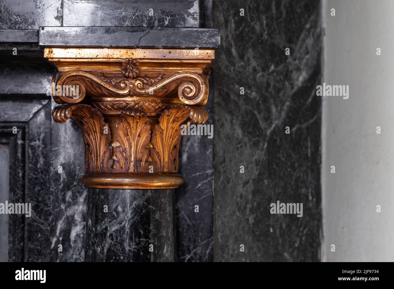 Pareti in marmo nero con decorazioni a colonne dorate. Dettagli interni classici di lusso. Foto Stock
