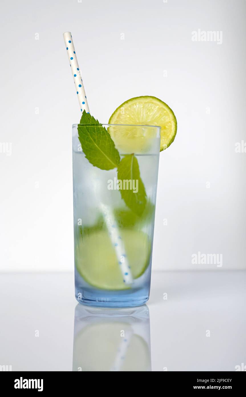 Mojito cocktail isolato su sfondo bianco in un vetro satinato blu chiaro Foto Stock
