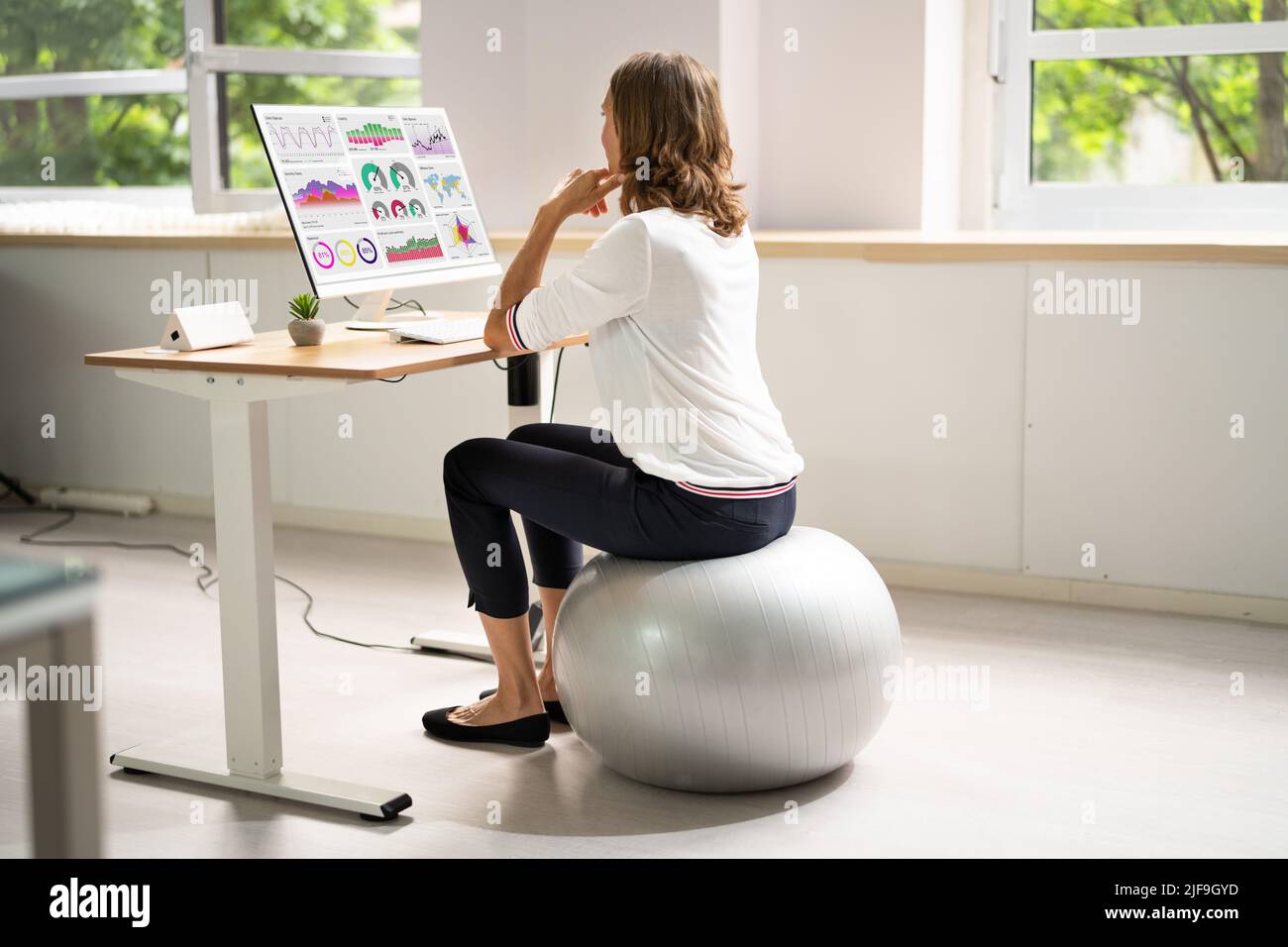 Correggere la postura alla scrivania in ufficio usando la sfera di idoneità Foto Stock
