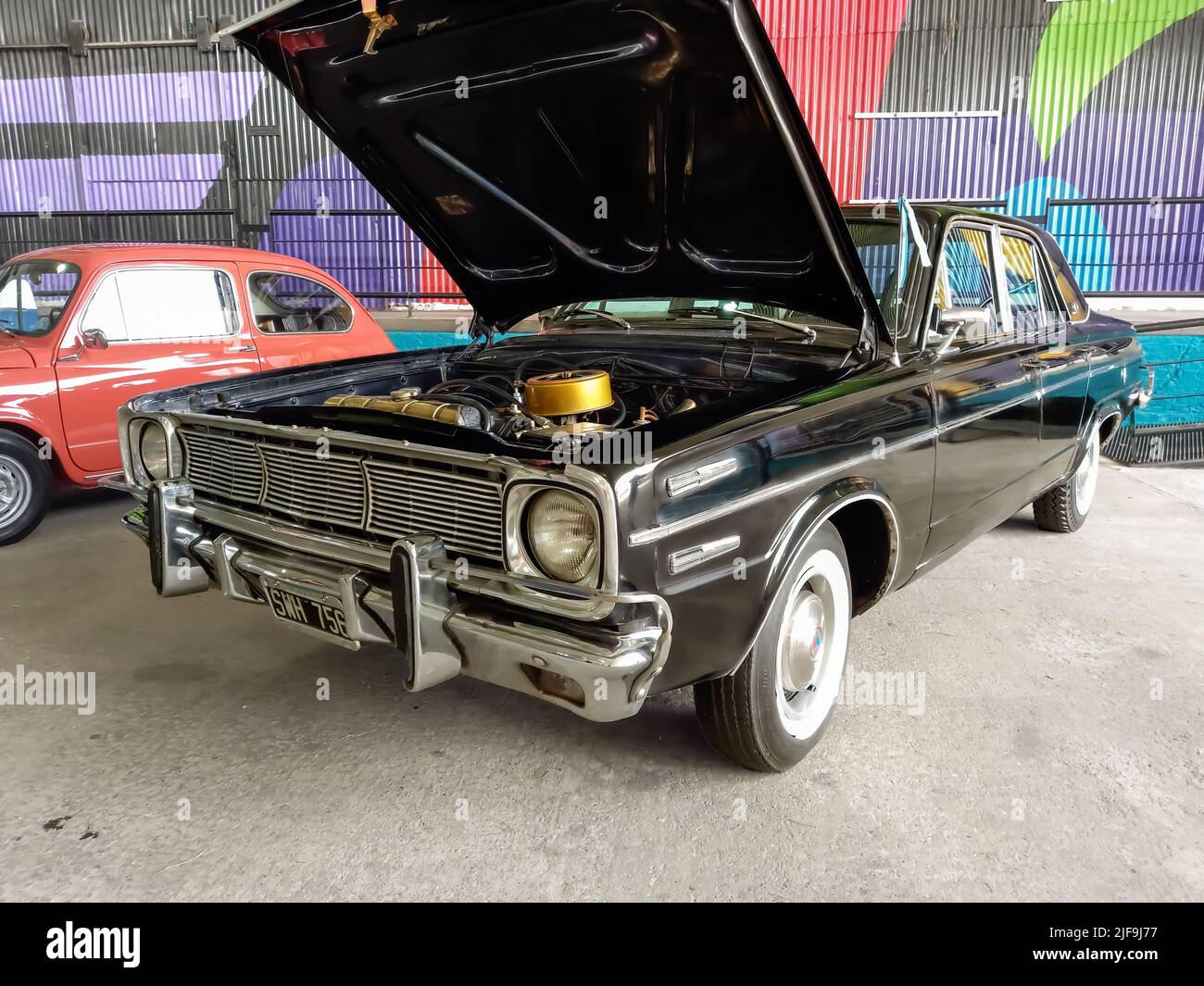 Vecchio nero Valiant VI 1960 di Chrysler compatto quattro porte berlina in un deposito. Aprire il cofano che mostra il motore. Mostra di auto classiche. CopySpace. Foto Stock