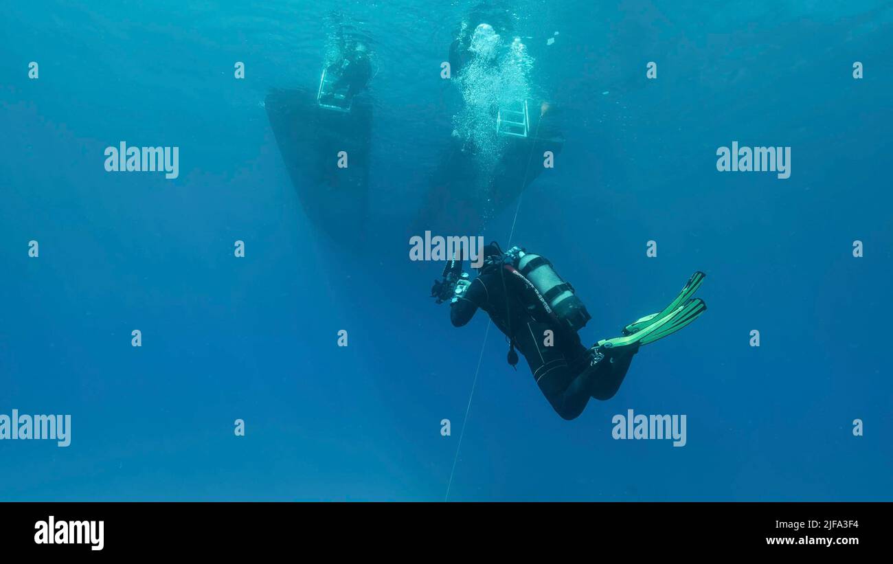 Il subacqueo nuota verso la barca subacquea in acqua blu. Mar Mediterraneo, Cipro Foto Stock