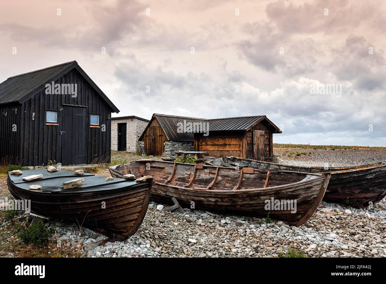 Vecchie capanne e barche di pescatori, luogo di pesca tradizionale, villaggio di pescatori, Helgumannen Fiskelaege, cielo nuvoloso, Isola di Faroe, Faroe, Gotland, Baltico Foto Stock