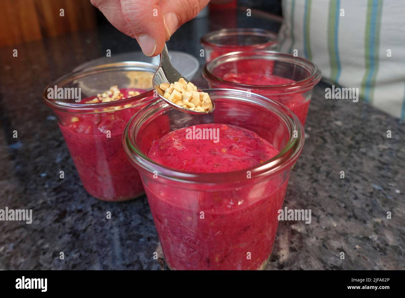 Cucina tedesca del sud, preparazione torta di noci con barbabietole, torta di barbabietole-carote in un vasetto, pasta, cospargere la massa con noci tostate, conservando Foto Stock