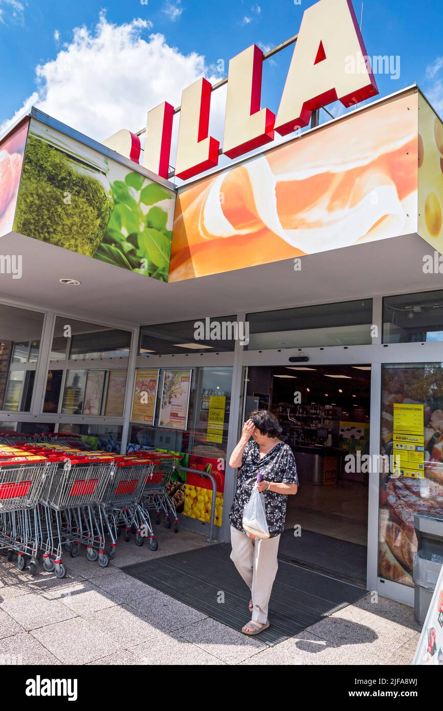 Donna anziana che lascia il supermercato Billa Foto Stock