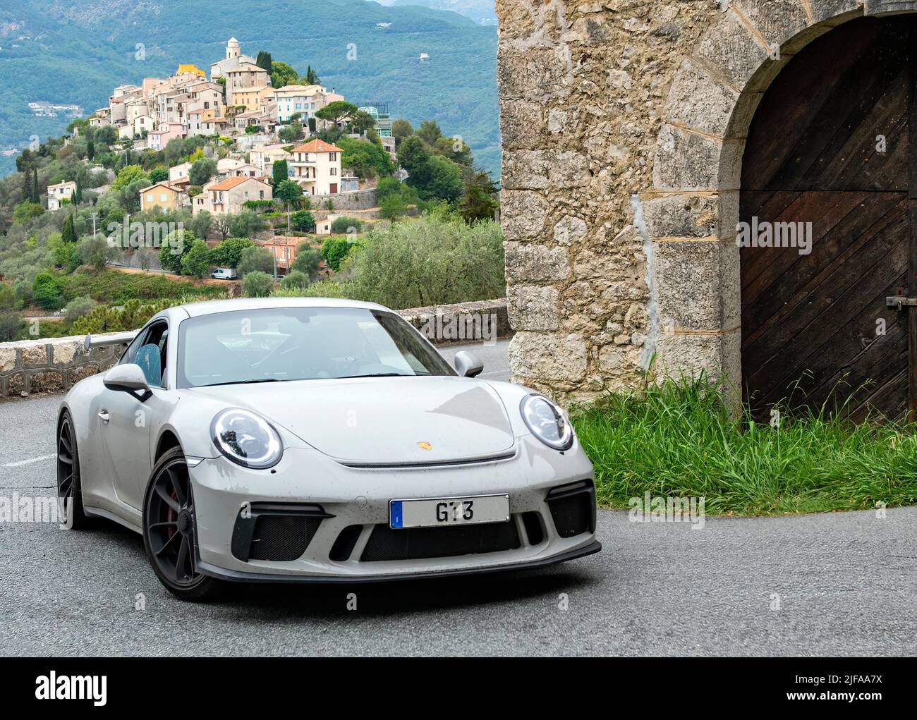 Supercar sportiva Porsche GT3 in curva stretta della storica sezione di pista del Rally Monte Carlo 1965, sullo sfondo la Roquette-sur-Var Foto Stock