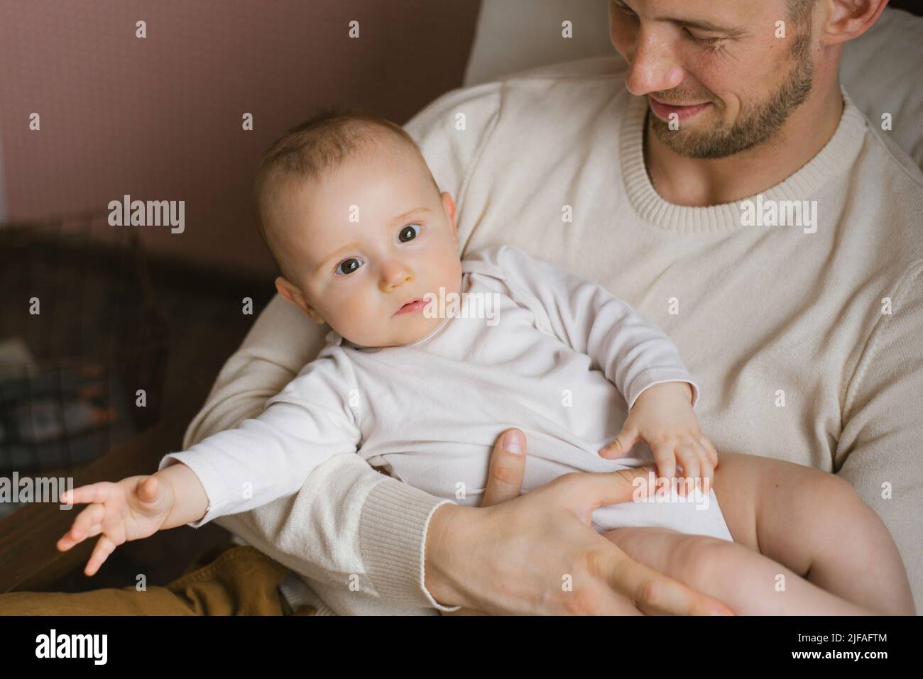 Un padre caucasico tiene il figlio fra le braccia. Buona paternità e famiglia Foto Stock