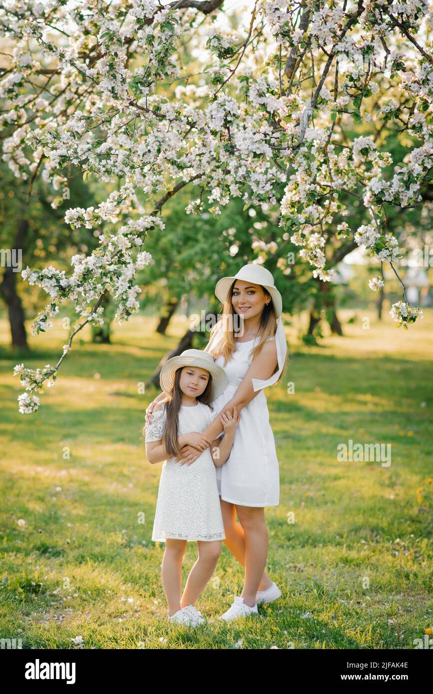 Bella e felice madre e figlia in un giardino di primavera in fiore. Amore dei genitori nella Festa della mamma. Foto Stock