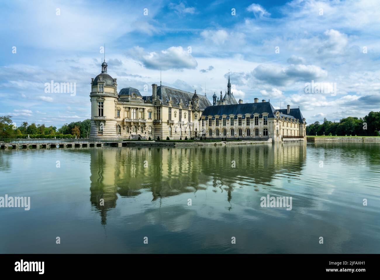 Il castello di Chantilly con riflessi d'acqua, nei pressi di Parigi Francia Foto Stock