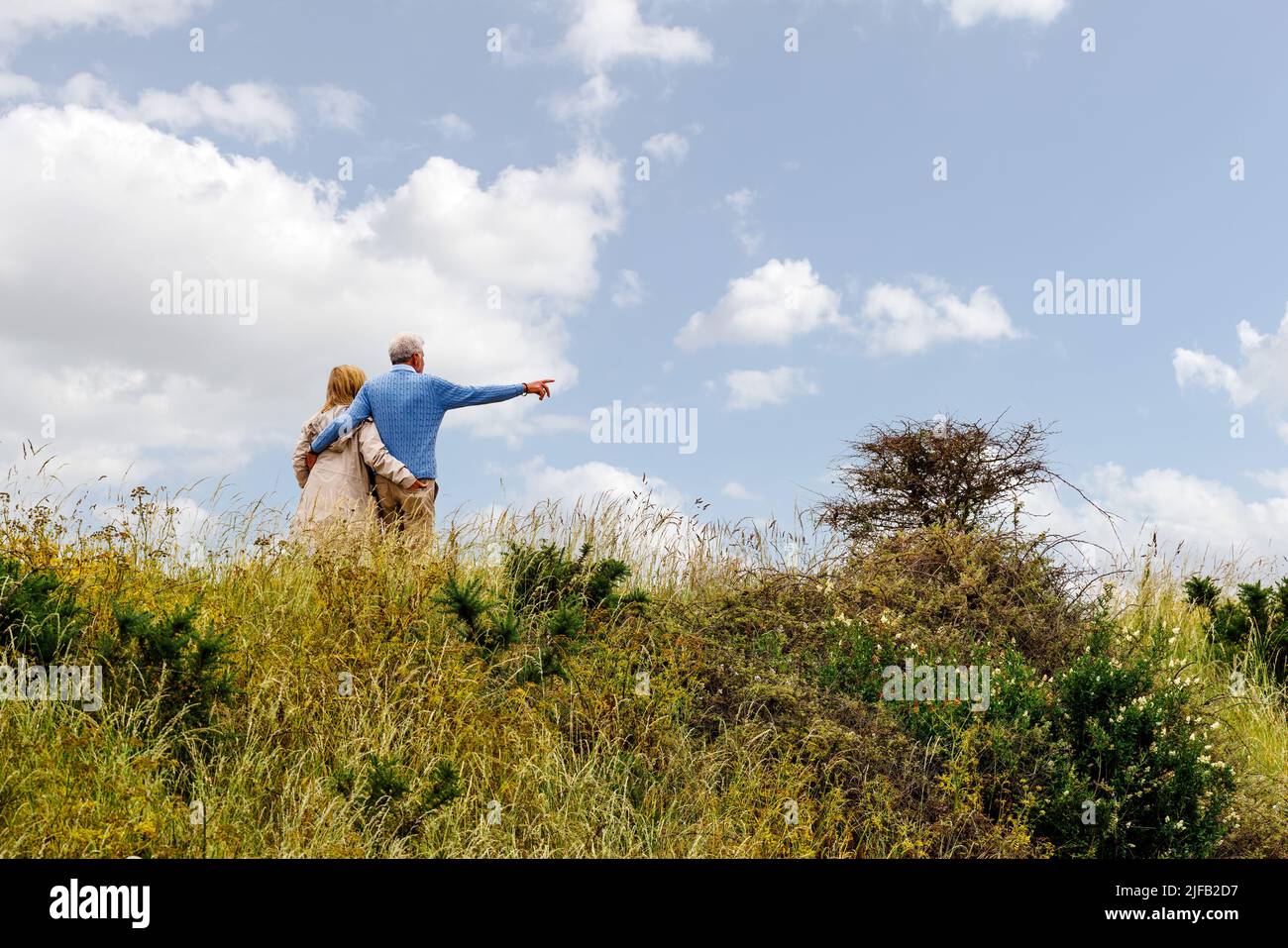 Una coppia anziana che ama camminare a Lymington e alla Keehaven Marshes Nature Reserve in una giornata estiva Foto Stock