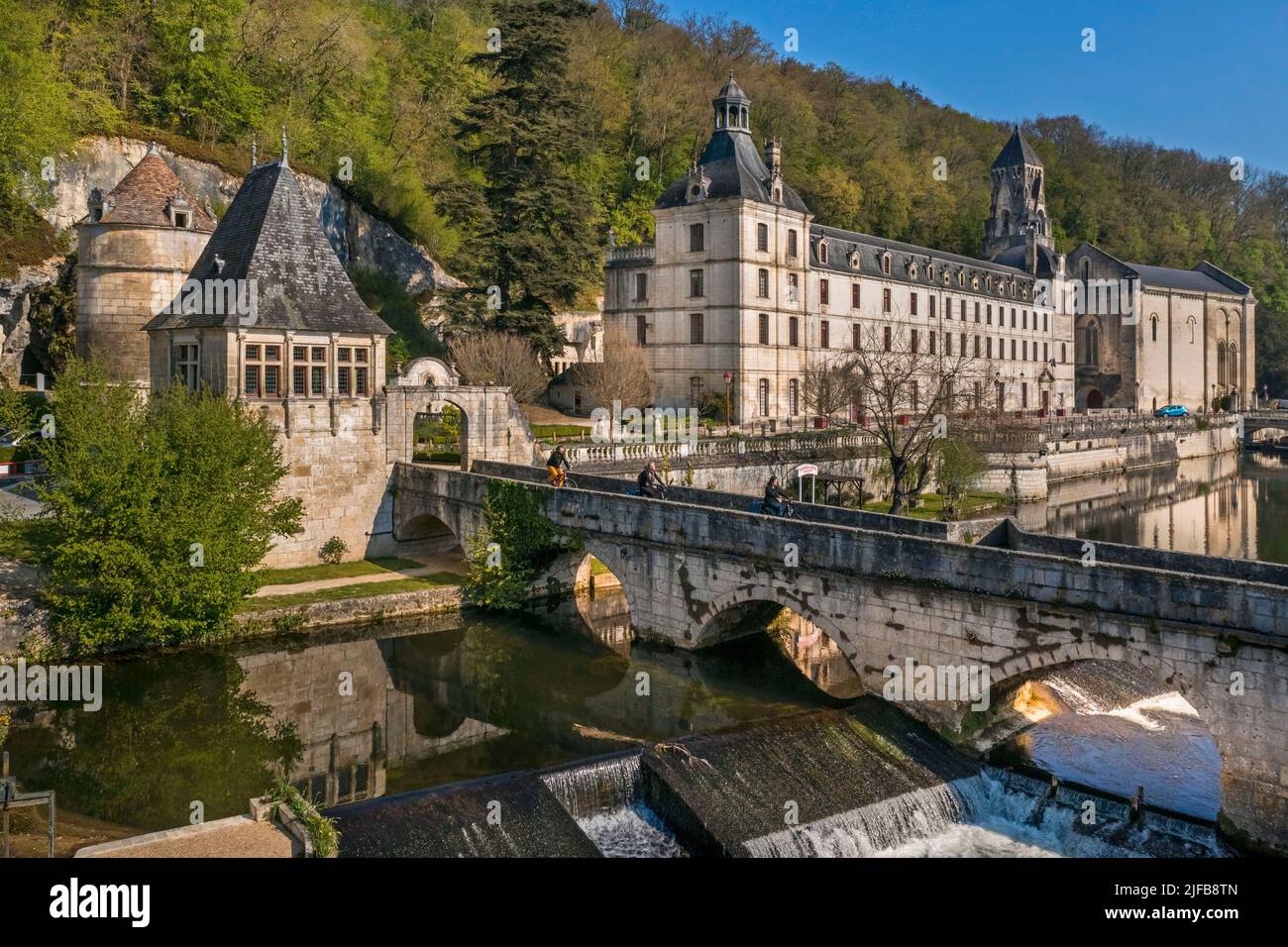 Francia, Dordogne, Brantome, ciclisti che viaggiano lungo la pista ciclabile Flow Vélo attraversando il Pont Coude (ponte ad angolo) sul fiume Dronne, Abbazia benedettina di Saint Pierre sullo sfondo (vista aerea) Foto Stock