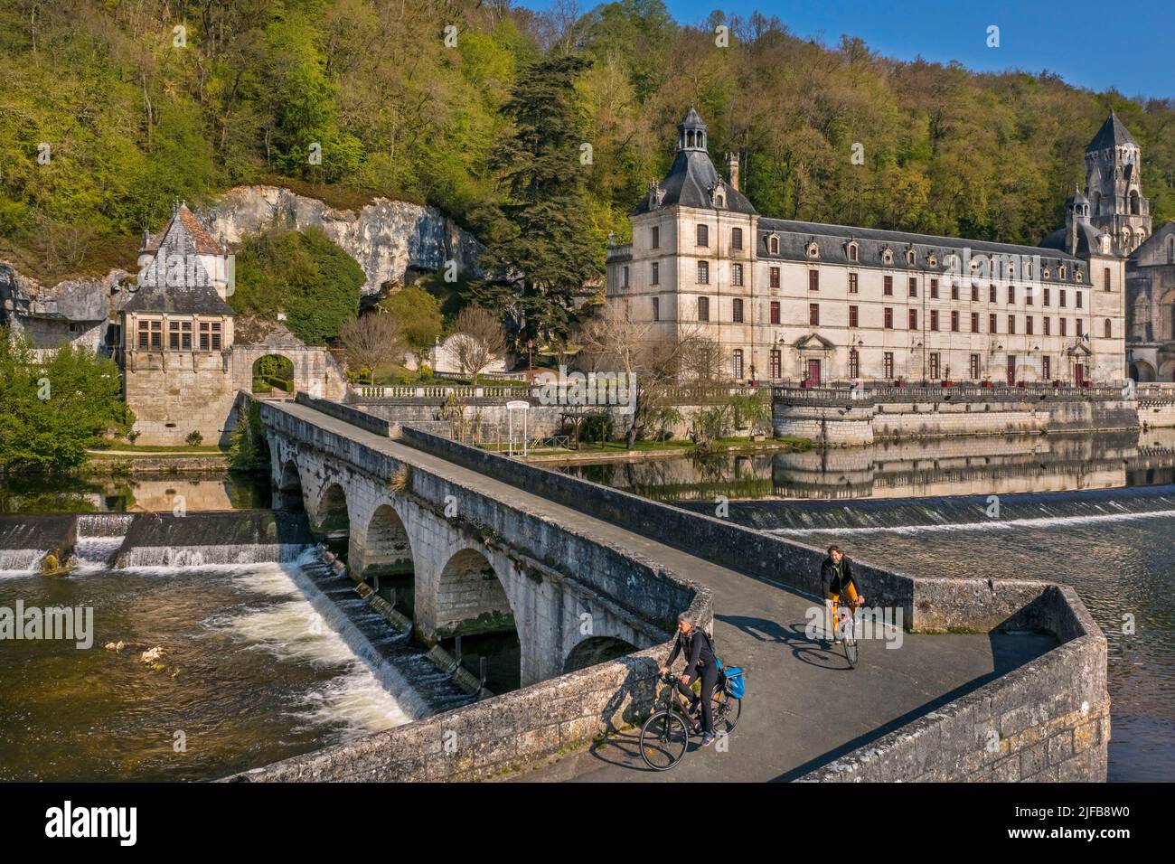 Francia, Dordogne, Brantome, ciclisti che viaggiano lungo la pista ciclabile Flow Vélo attraversando il Pont Coude (ponte ad angolo) sul fiume Dronne, Abbazia benedettina di Saint Pierre sullo sfondo (vista aerea) Foto Stock