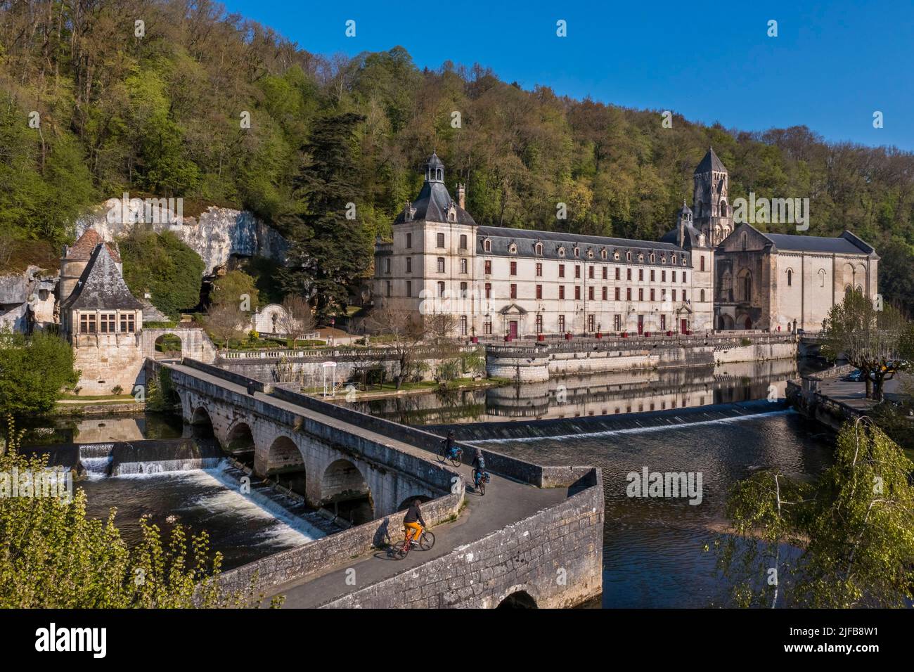 Francia, Dordogne, Brantome, ciclisti che viaggiano lungo la pista ciclabile Flow Vélo attraversando il Pont Coude (ponte ad angolo) sul fiume Dronne, Abbazia benedettina di Saint Pierre sullo sfondo (vista aerea) Foto Stock