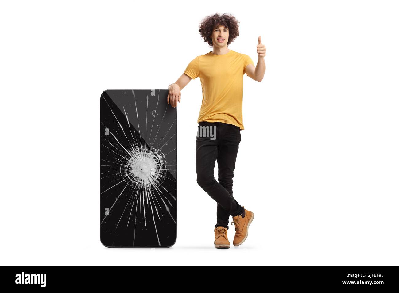 Ragazzo con uno smartphone rotto che mostra i pollici isolati su sfondo bianco Foto Stock