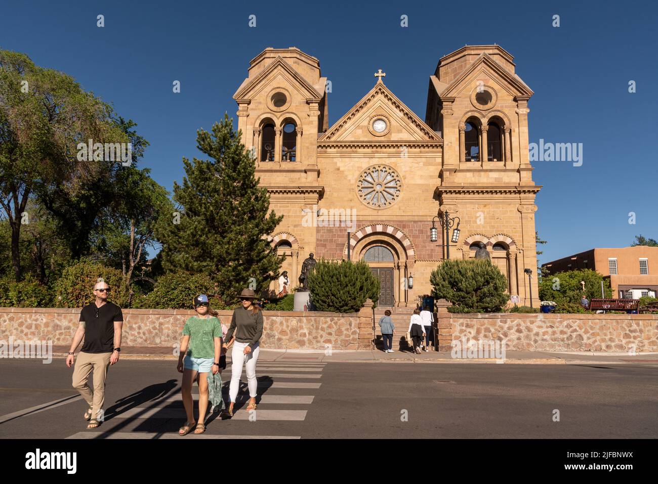 Una famiglia nel marciapiede di fronte alla Basilica Cattedrale di San Francesco d'Assisi a Santa Fe, nuovo Messico, Stati Uniti. Foto Stock