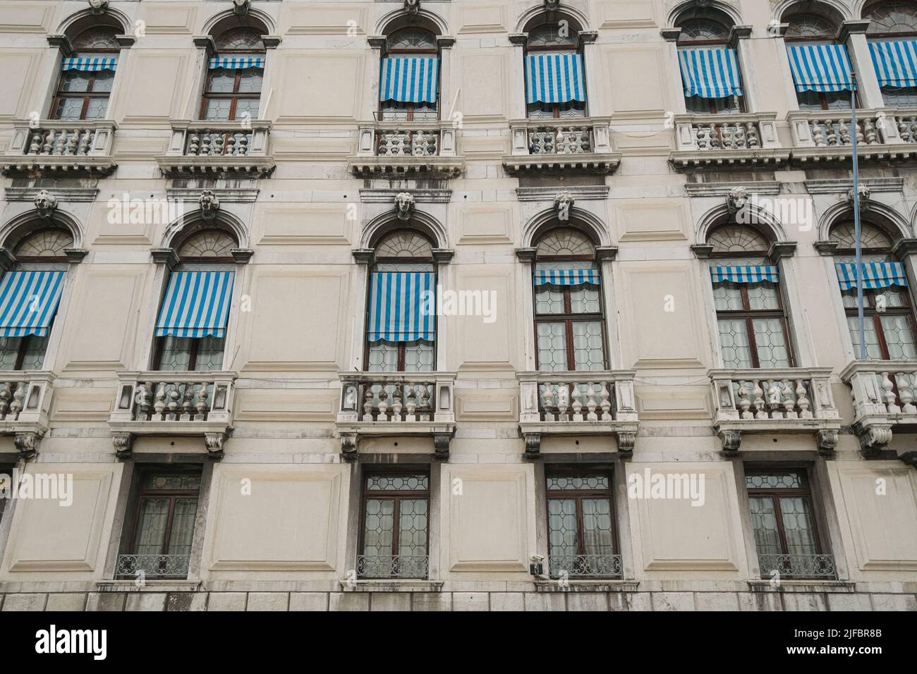 Le tradizionali finestre gotiche si affacciano sul vecchio edificio del centro storico di Venezia, monumenti architettonici italiani Foto Stock