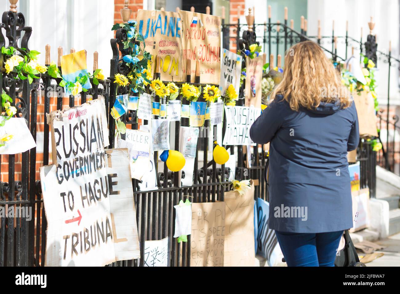 I messaggi e i poster contro l’invasione dell’Ucraina da parte della Russia sono visti a sinistra vicino all’ambasciata russa a Londra. Foto Stock