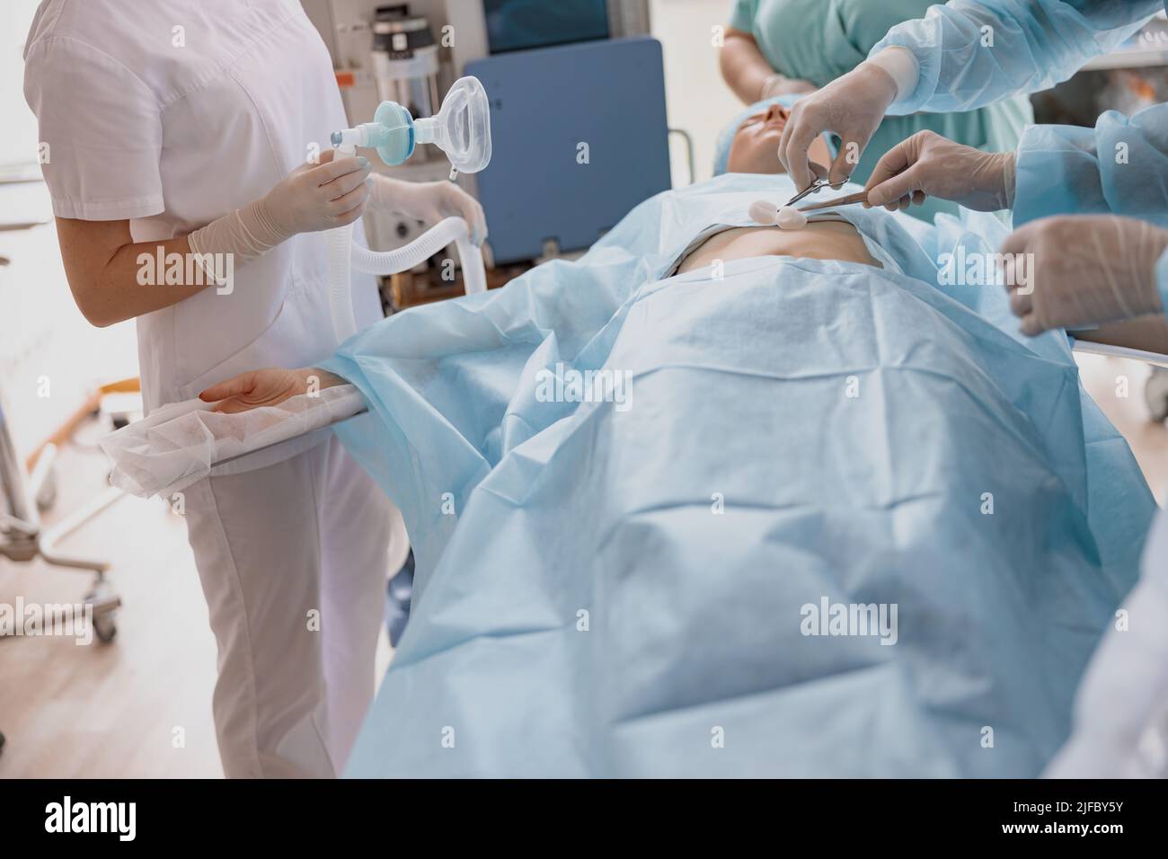 Primo piano di infermiere e medico preparare la pelle del paziente per l'intervento chirurgico utilizzando soluzione antisettica Foto Stock