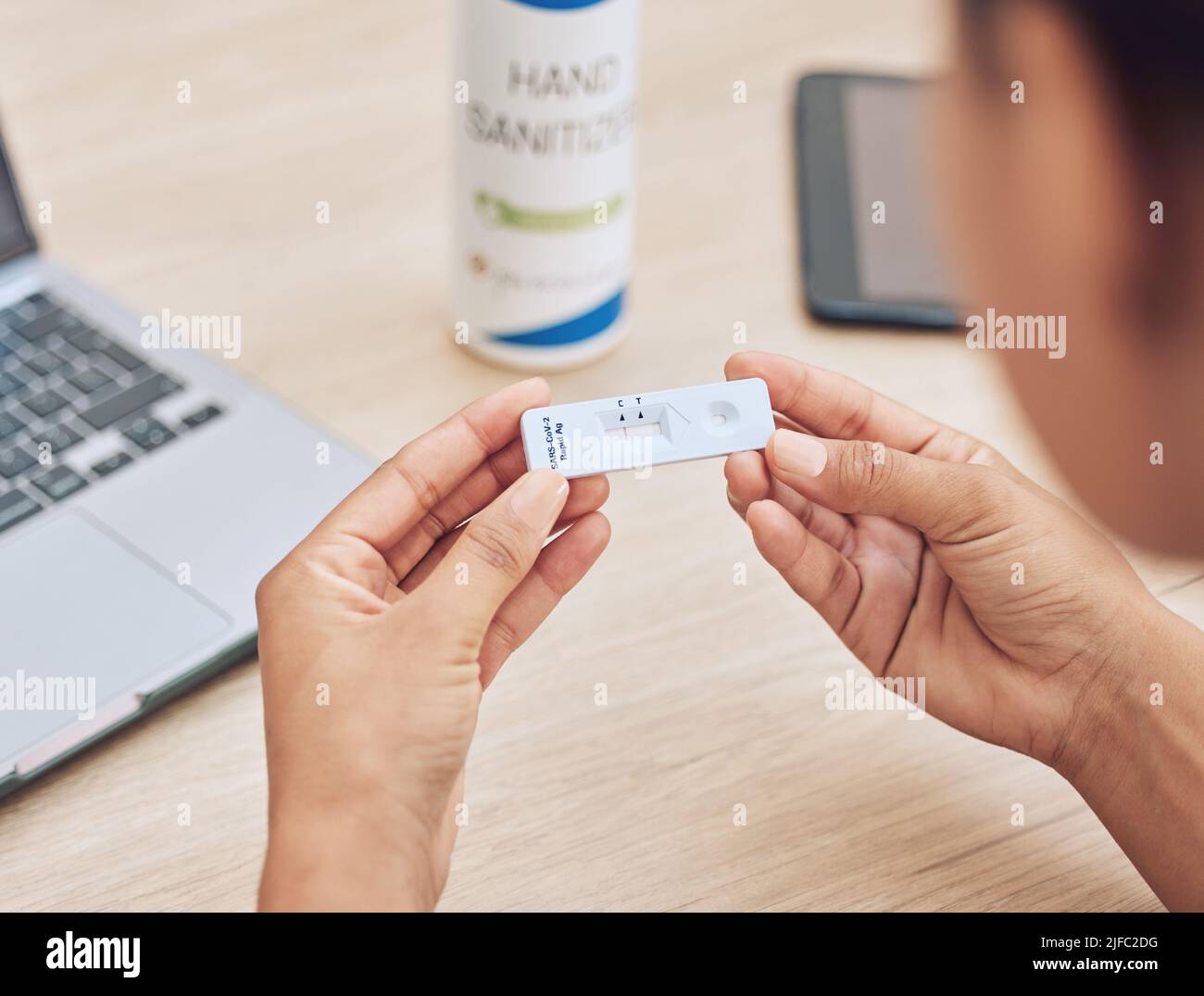 Primo piano di una gara mista irriconoscibile donna in possesso di un kit di test rapido. Lavoratore di ufficio femminile che detiene un kit di test del virus corona al lavoro per Foto Stock
