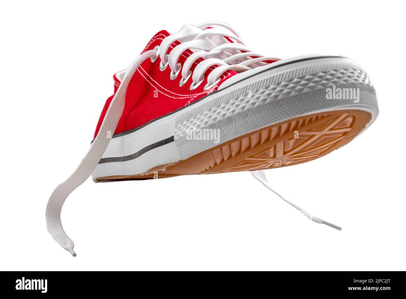 Scarpe sportive in tela rossa vintage con lacci, adatte per giocare a basket, tennis o running, isolate su bianco con ritaglio percorso conc Foto Stock