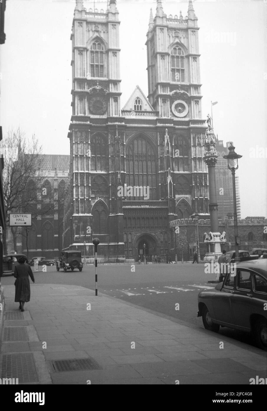 1952, vista storica, dall'esterno di Westminster Abbey, Londra, Inghilterra, Regno Unito, fuliggine coperta in quest'era del dopoguerra. Dal 1066, sede di tutte le nazioni dei monarchi inglesi e britannici, la chiesa è di proprietà diretta della famiglia reale Briitsh. Cartello per il Central Hall sulla sinistra, un Metodista Central Hall che ha aperto nel 1912 e dove si svolgono dibattiti ed eventi. Foto Stock