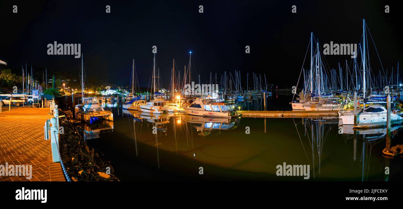 Una vista notturna della Marina tropicale che riflette le barche e le luci del porto Foto Stock