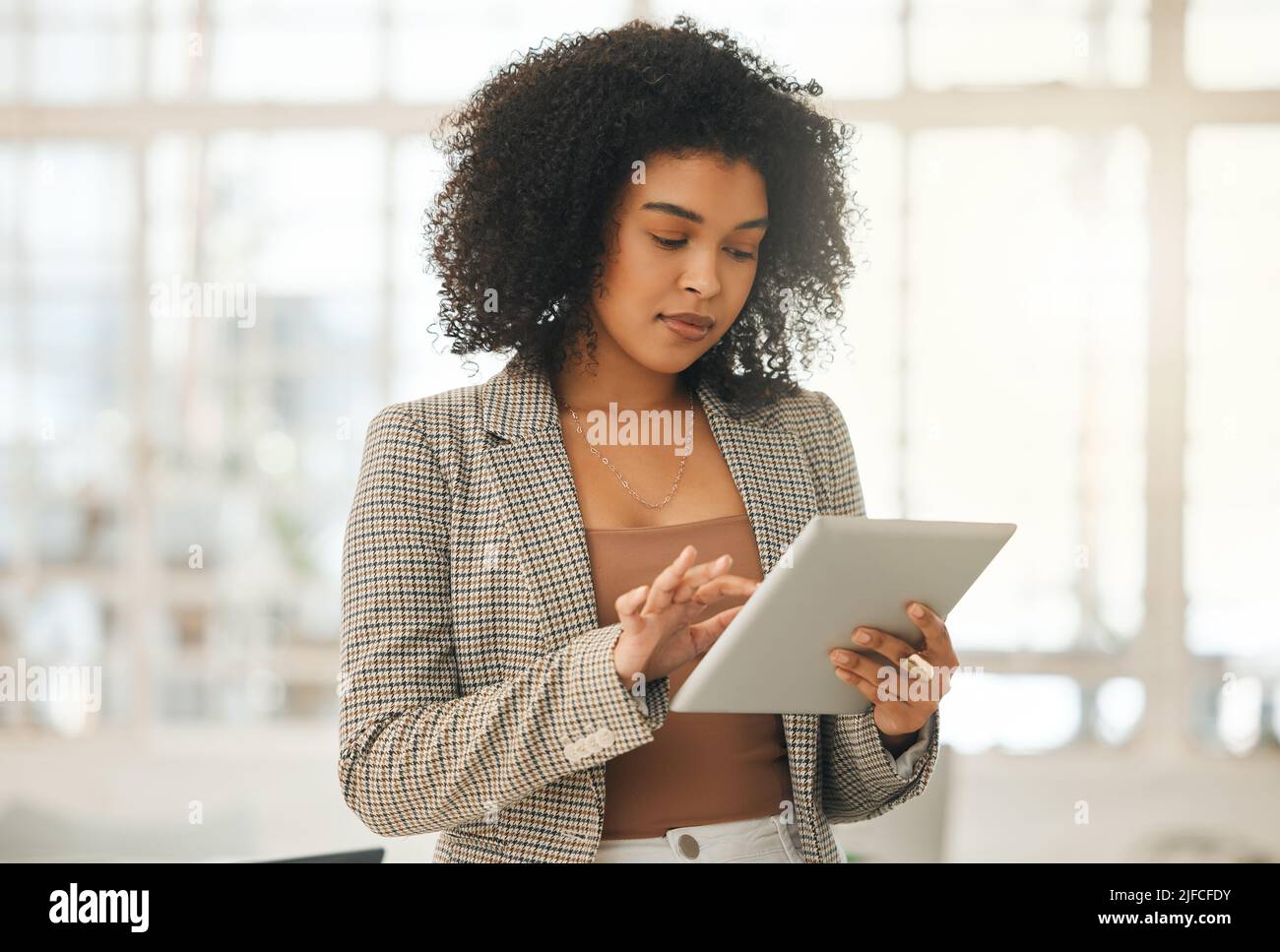 Giovane donna d'affari che usa un tablet digitale. Designer concentrato nella sua agenzia. Imprenditore creativo che lavora su un dispositivo wireless. Giovane Foto Stock