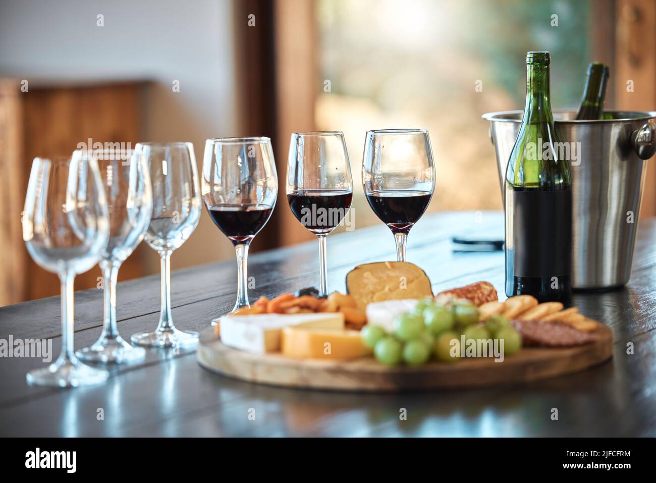 Una fila di bicchieri e un tabellone di formaggi allestiti per una degustazione di vini all'interno di un ristorante. Un piatto di formaggi il vino giusto è l'abbinamento perfetto per un Foto Stock