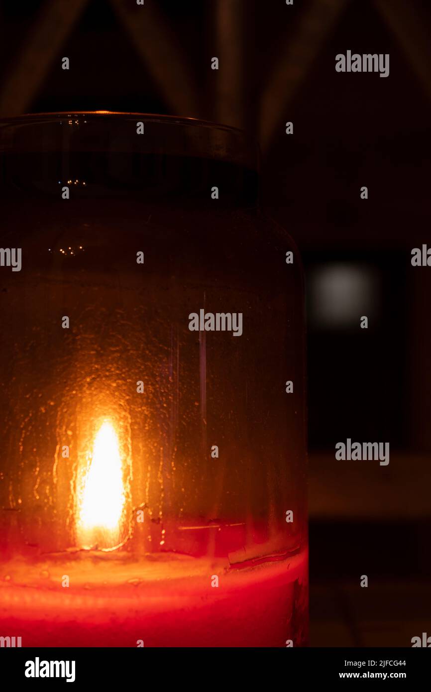 primo piano candela rossa in un vaso di vetro di notte Foto Stock
