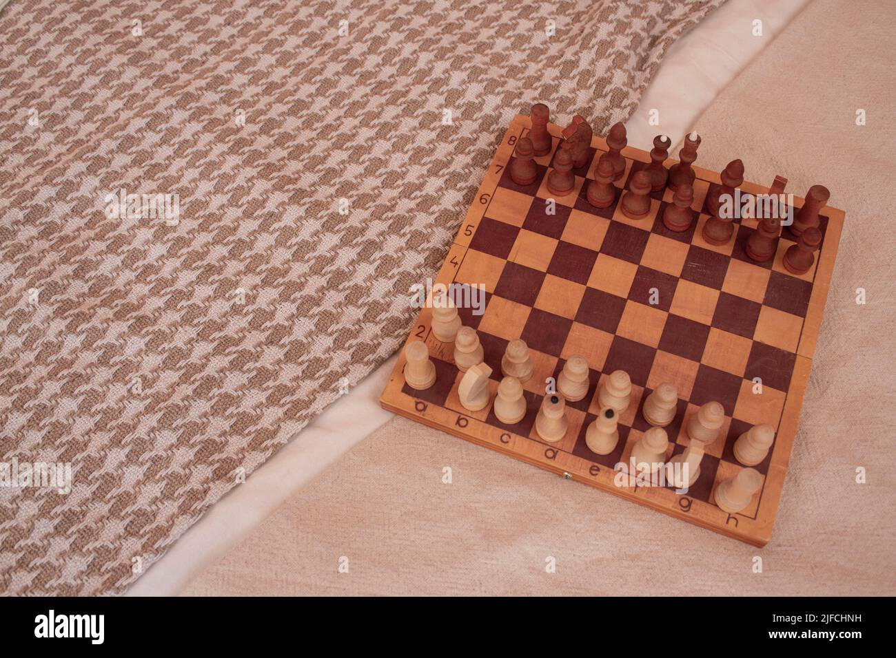 Scacchiera e scacchi in legno a letto. Processo di gioco Foto Stock