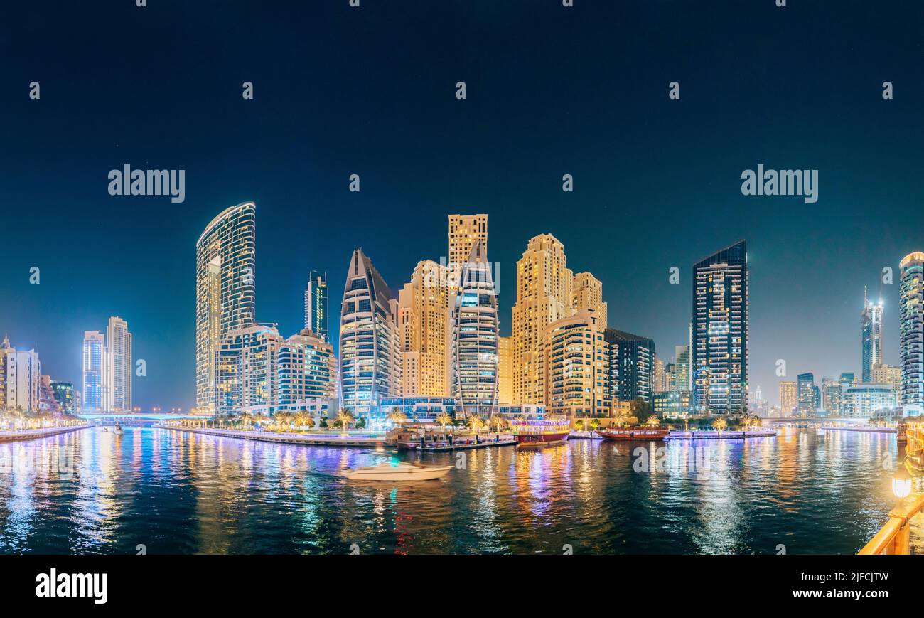 Splendida vista notturna di alti edifici del quartiere residenziale a Dubai Marina e Tourist Boat, Barca turistica vela a Dubai Marina Foto Stock