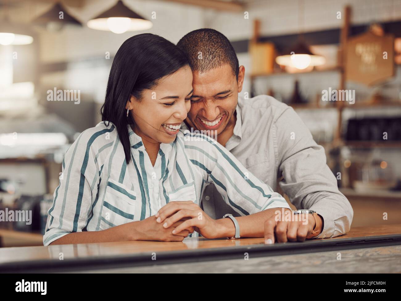 Amorevole coppia di gara mista ridendo e godendo il tempo insieme il primo giorno. Giovane donna e uomo in una data caffè in un caffè Foto Stock