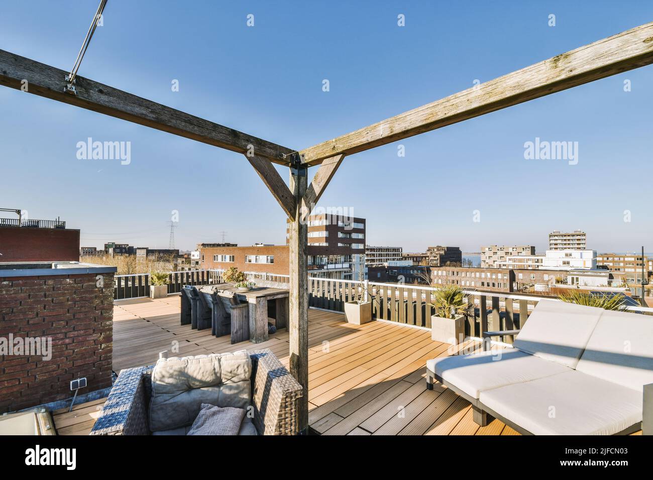 Vista sulla città dalla terrazza con tavolo e sedie situata sul tetto di un edificio di appartamenti Foto Stock