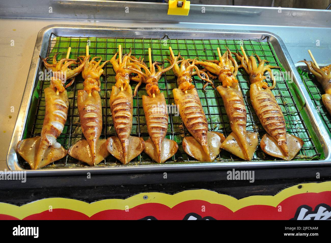 Cibo tailandese di strada - barbecue alla griglia Squid su un bastone Foto Stock